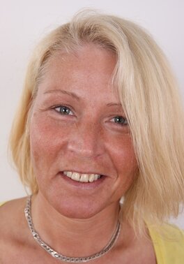 Photographer takes pictures of cheerful mature woman with blonde hair