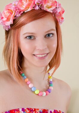 Red-haired cutie seductively takes off sweet dress and poses nude near table