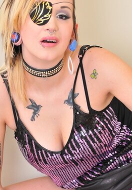 Girl with nose and low lip piercing wears pirate blindfold in solo naked pictures