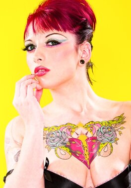 Sweetie with middle-sized boobs starts striptease on a yellow background