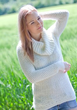 Cute young babe posing nude in the field and showing her shaved pussy