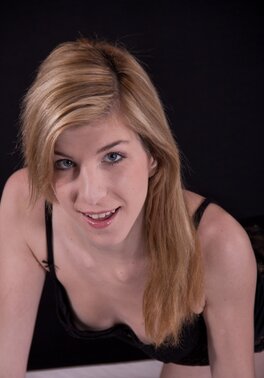 Small-tittied cutie in black stockings reveals body lying on the bed