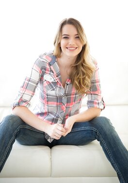 Slim beauty takes off jeans with intention to touch sweet cunny on sofa