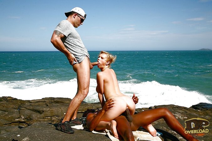 Busty blonde MILF double penetrated on rocky coast by white and black guys