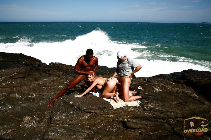 Busty blonde MILF double penetrated on rocky coast by white and black guys