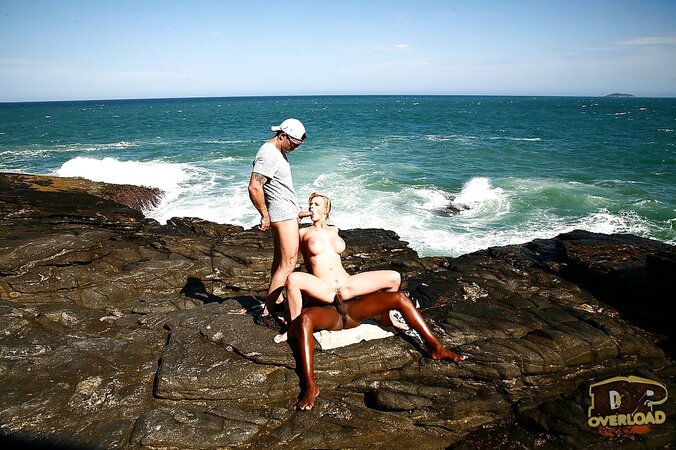Busty blonde MILF double penetrated on rocky coast by white and black guys