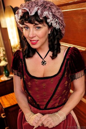 Smiling brunette housemaid is posing when black employer catches her and watches