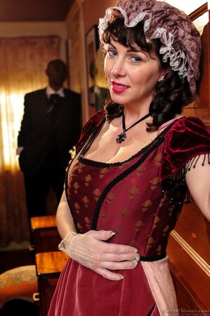 Smiling brunette housemaid is posing when black employer catches her and watches
