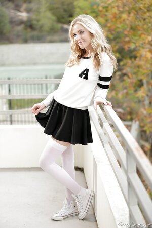 Blonde cutie poses naked outdoors just wearing white stockings and canvas shoes