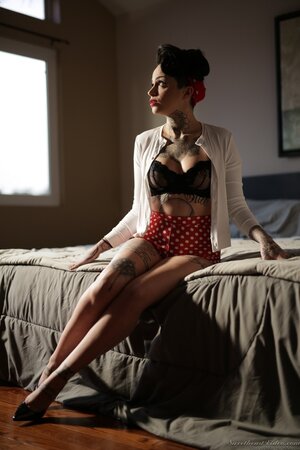 Inked brunette has enough talent to pose naked in image of pinup model