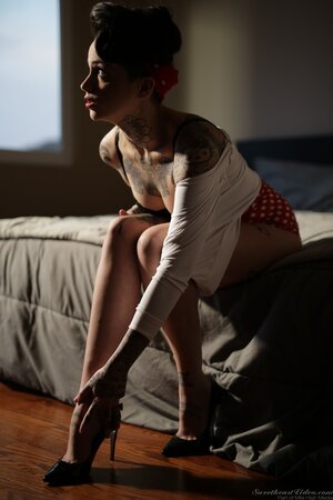 Inked brunette has enough talent to pose naked in image of pinup model