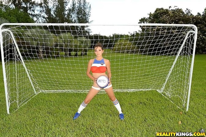 Natural goddess with provocative body painting poses outdoors near goal