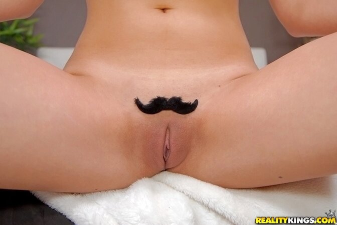 Chick with big boobs poses naked with funny mustache-looking wigs on the pussy