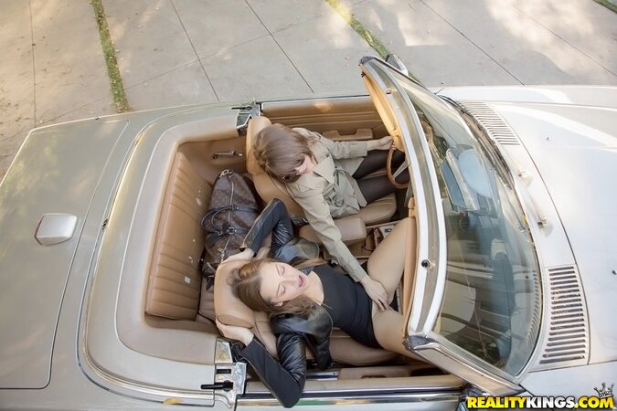 Two excited girlfriends find quiet spot perfect to have fun in roadster
