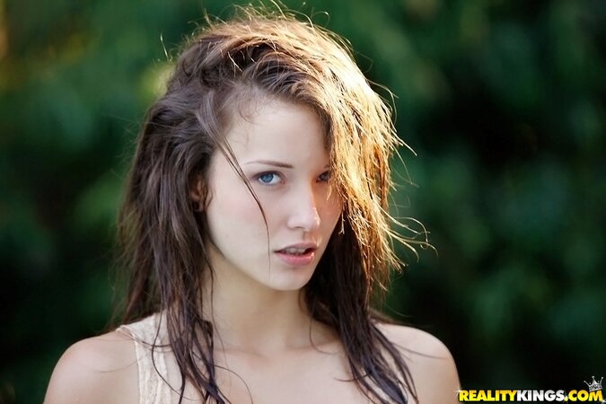 Enticing cutie with perky tits seductively poses outdoors after rain