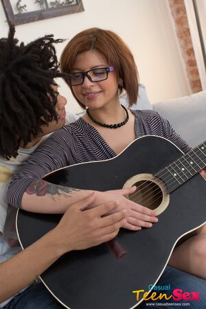 Ebony guy plays on guitar making nerdy redhead Rebecca Rainbow in mood for sex