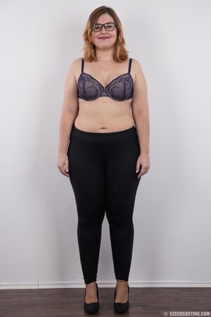 Fat whore with glasses rocks out in the porn studio trying striptease skills out