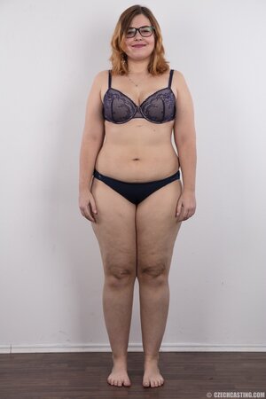 Fat whore with glasses rocks out in the porn studio trying striptease skills out