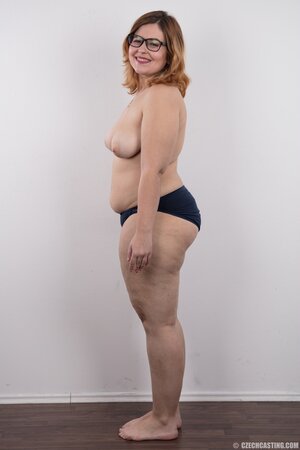 Fat whore with glasses rocks out in the porn studio trying striptease skills out