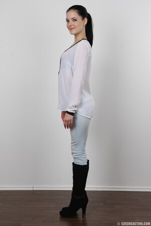 Young woman in jeans and high black boots strips down for a porn ballyhoo