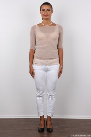Female with green eyes wears white pants and bra but black panties at photoshoot