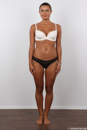 Female with green eyes wears white pants and bra but black panties at photoshoot