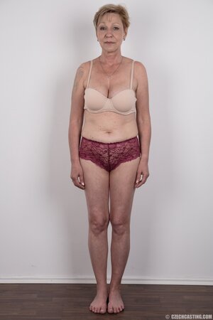 Mature porn model with tattooed shoulder advertises natural twins and slit