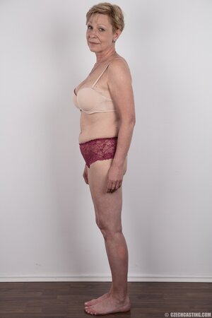 Mature porn model with tattooed shoulder advertises natural twins and slit