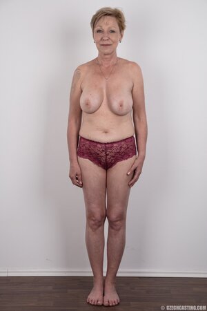 Mature porn model with tattooed shoulder advertises natural twins and slit