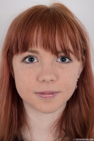 Female with red hair and colored rose tattooed on pale body strips down
