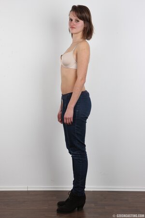 Female smiles so shy but still keeps on stripping naked in photo studio