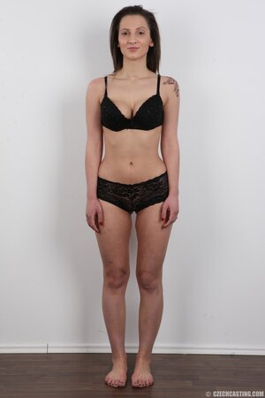 Young woman with cunning smile leaves nothing on sitting on a stool naked