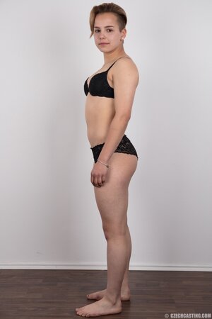 Young woman with small nice boobies and boyish figure doesn't shy to get naked