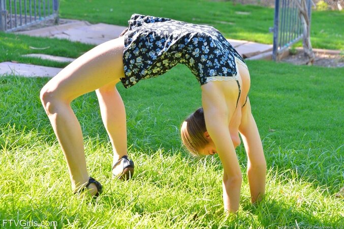 Babe ties hair in a pigtail and eats banana with her hungry muff in the park