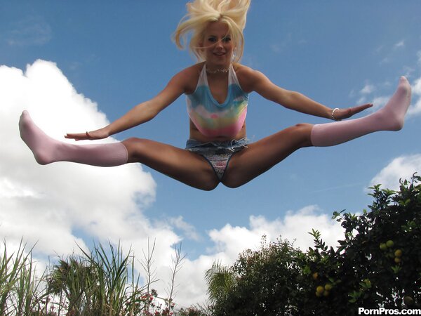 Cheerful young woman jumps on a trampoline and exposes her big tits