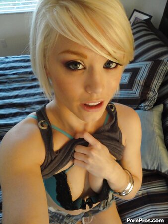Blonde girl in green lingerie takes nude selfies in front of a big mirror