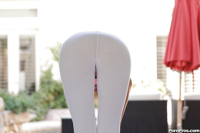 Well-shaped babe pulls yoga pants down to show hair-lined pussy while stretching