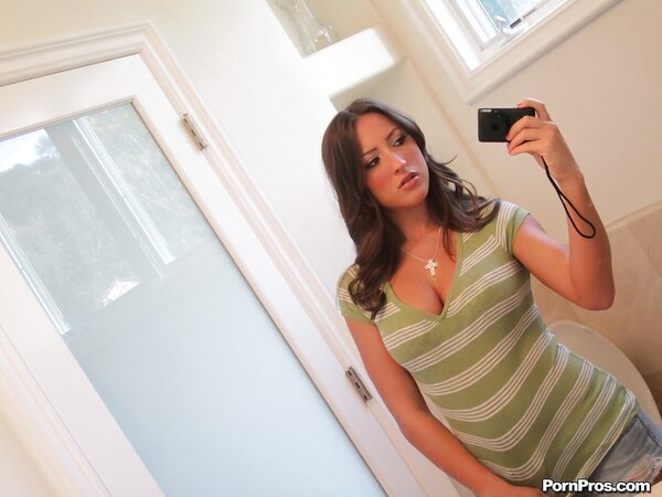 Chick takes her T-shirt and jean shorts exposing tattooed belly in front of mirror