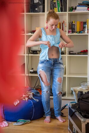 Small-boobied Virginee Spice pulls on jeans and small top after posing nude