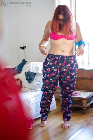 Plus-sized redhead on pink lingerie to get fully dressed next to the window