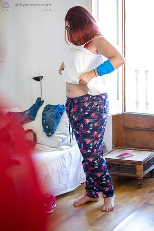 Plus-sized redhead on pink lingerie to get fully dressed next to the window