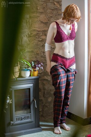 Pale redhead chick covers natural boobs with burgundy lingerie on the spy camera