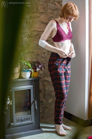 Pale redhead chick covers natural boobs with burgundy lingerie on the spy camera