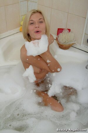 Pleasant blonde takes off lingerie and dives into bathtub where has fun