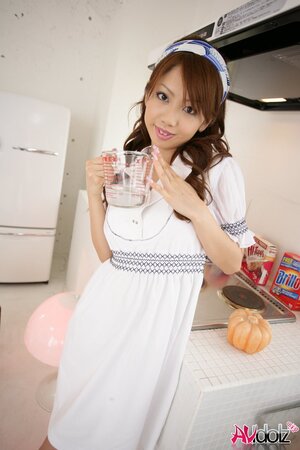 Modest Japanese sweetie dressed in white dress that accentuates her slimness