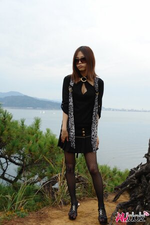 Asian girl with sunglasses on looks so seriously cause she is shy being naked
