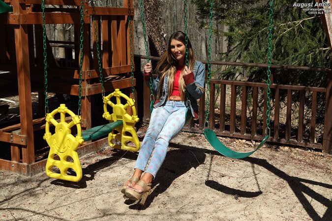 Hottie in denim jacket licks a lollipop and plays with pussy on a swing
