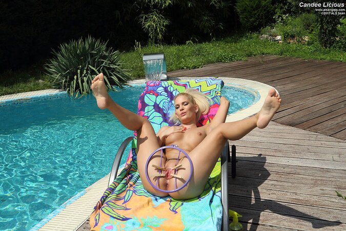 Teen is shaded on a deckchair spreading and rubbing her twat with a lollipop