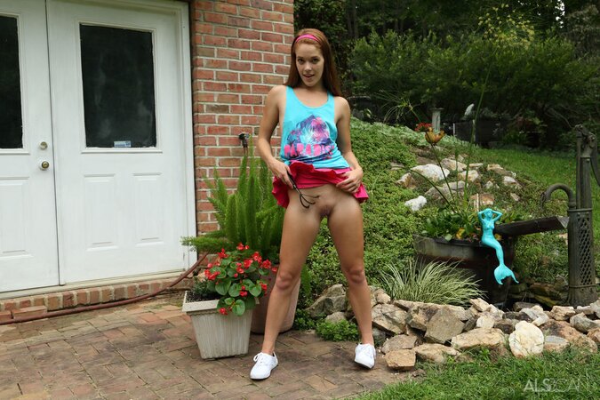 Hungry girl masturbates with a water hose and small rakes in the backyard