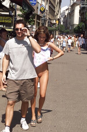 Whore in high heels gets naked and poses in the nude on the crowded street